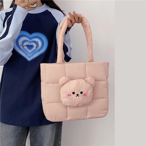 Detailed shot of pink quilted nylon bag featuring a cute 3D plush bear ornament