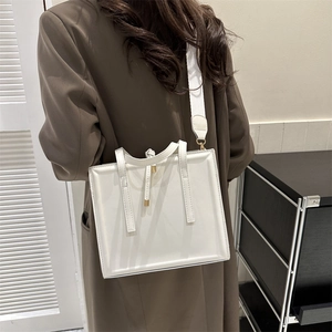 Detailed side view of a white minimalist PU leather crossbody bag with wide fabric strap