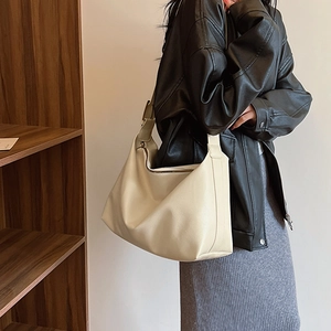 Detail of cream oversized hobo bag showing soft lychee grain texture and wide strap