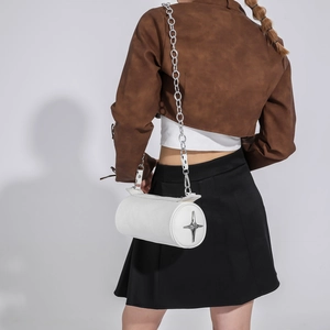 Detailed back view of white cylinder bag with silver star emblem and chunky metal chain