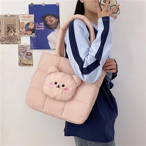Detail of pink quilted tote bag featuring a 3D plush bear head and thick shoulder straps