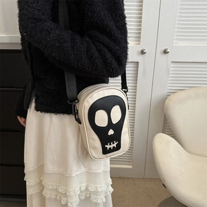Détail du sac à bandoulière en cuir PU crème avec motif tête de mort noire et sangle nylon