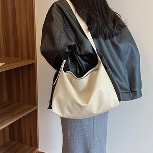 Detailed close-up showing the creamy white lychee grain leather texture of the hobo bag
