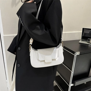 Minimalist white PU leather crossbody bag worn with a black blazer in office setting