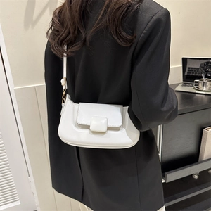 Minimalist cream white crossbody bag shown on a black suit jacket for professional use