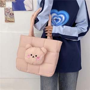 Detailed view of pink quilted tote bag with a 3D plush bear head and square stitching