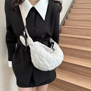 Detail view of a white quilted crescent crossbody bag with a round mini coin purse pouch