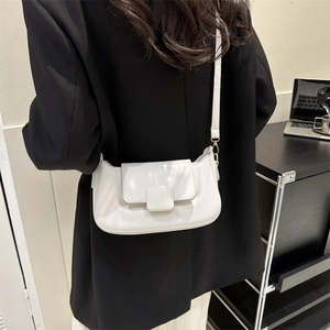Detailed view of a white PU leather crossbody bag featuring a square buckle on a model