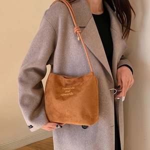 Brown suede crossbody bag featuring yellow onwards and upwards text embroidery detail