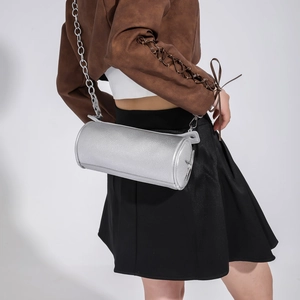 Detail of silver cylindrical crossbody bag with metallic lychee grain and star ornament