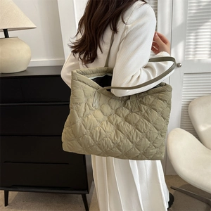 Sac fourre-tout matelassé vert sauge porté montrant la texture douce et volumineuse