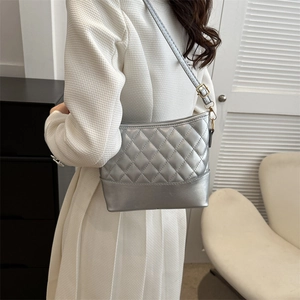 Silver quilted PU shoulder bag with metallic finish and gold buckles shown on model