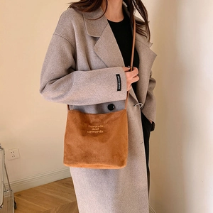 Brown suede crossbody bag with Onwards and Upwards embroidery detail on minimalist leather