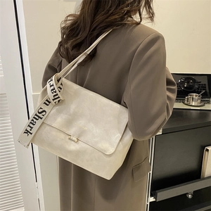 Detail of cream PU leather shoulder bag featuring a unique Shark printed woven strap