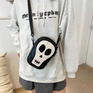 Détail du sac bandoulière avec design de crâne et bandoulière en nylon sur un mannequin