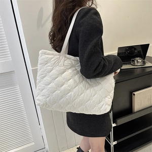 Vue latérale d'un grand sac cabas matelassé blanc sur modèle au design bouffant moderne
