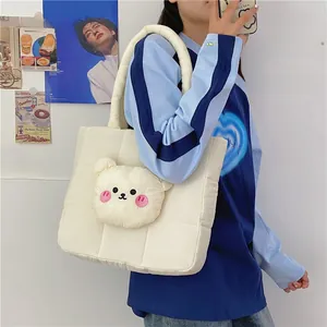 Detail of white quilted nylon shoulder bag featuring a cute 3D plush bear head decoration