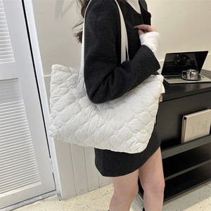 Gros plan sur un grand sac cabas blanc matelassé avec des coutures en losanges chic