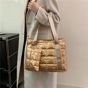 Golden metallic quilted tote bag with padded texture and matching small pouch