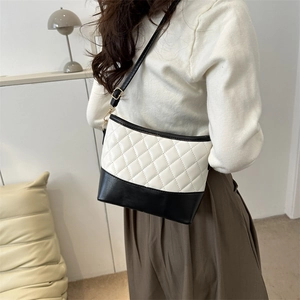 Detail of crossbody bag with black and white color blocking and diamond quilting