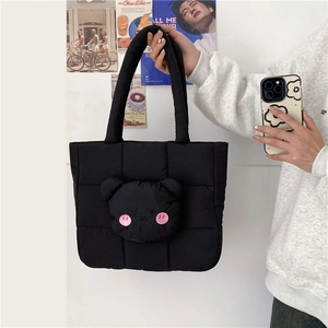 Detailed shot of a black quilted tote bag featuring a cute 3D bear head with pink embroidery