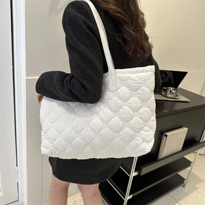 Détail d'un cabas blanc matelassé avec motif à losanges et fines bandoulières élégantes