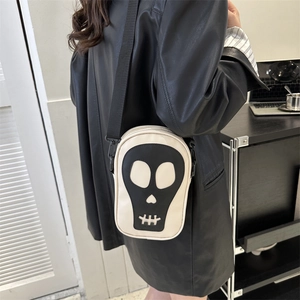 Vue latérale d'un sac bandoulière tête de mort porté avec une veste en cuir noir