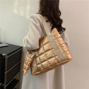 Detail of gold quilted nylon tote bag with matching coin purse and wide shoulder strap