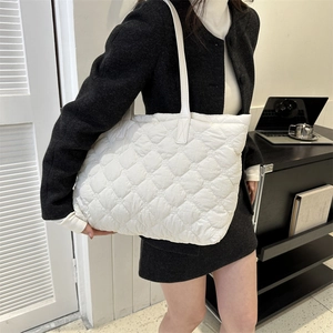 Gros plan sur le tissu matelassé blanc et la texture rembourrée du grand sac fourre-tout