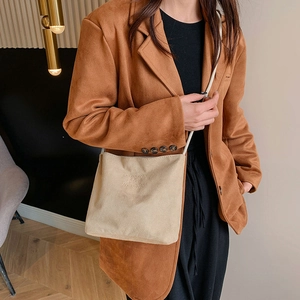Detailed texture of suede crossbody bag with onwards and upwards embossed letters
