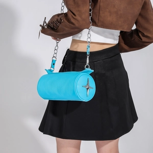 Detail view of electric blue cylinder bag with silver star emblem and chunky chain strap