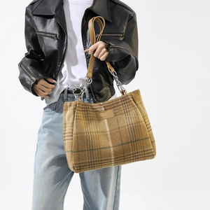 Chic checkered wool tote bag with leather strap and silver chain detail on a model