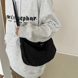 Minimalist black quilted crossbody bag in nylon with adjustable shoulder strap for women