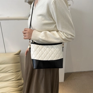 Detailed view of the black and white quilted crossbody bag with premium stitching details