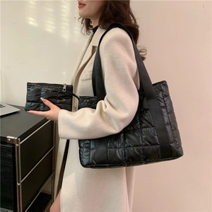 Detailed view of black quilted nylon tote bag with matching small zippered pouch set
