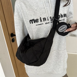 Detail of black quilted nylon crescent crossbody bag with a round coin purse on strap