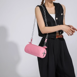 Detail of pink cylindrical PU leather bag with silver star decor and chain strap
