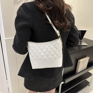 White quilted crossbody bag with golden metal buckle shown on a model from back view