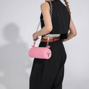 Detail of pink cylindrical PU leather bag with silver star buckle and metal chain