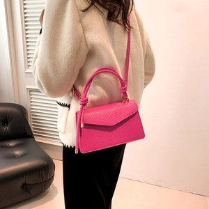 Borsa a mano fucsia testurizzata con manico annodato indossata da una modella