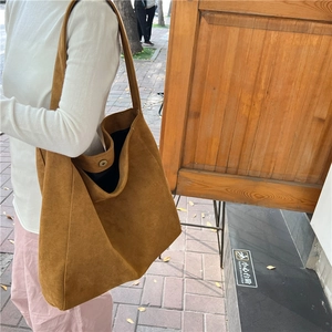 Detail shot of the large dark brown suede hobo tote bag with visible magnetic closure