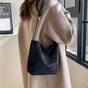 Minimalist black faux suede crossbody bag with onwards and upwards embossed text and knotted strap