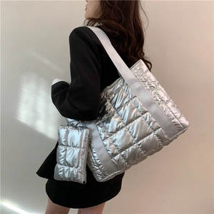 Close-up of a silver quilted tote bag with a matching small coin purse and wide strap