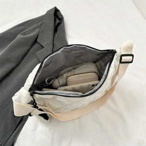 Top view of open white quilted crossbody bag showing large capacity for phone and umbrella
