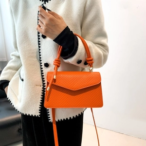 Dettaglio della borsa in pelle arancione con design unico del manico a nodo elegante