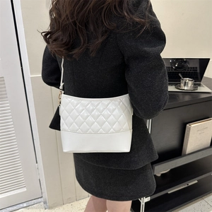 Detail view of white quilted PU leather crossbody bag with golden metal hardware and strap
