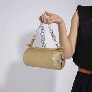 Close-up of golden cylinder handbag with silver star metal hardware and chunky chain strap