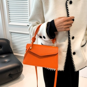 Dettaglio borsa in pelle PU arancione brillante con hardware dorato e tracolla sottile