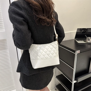 Close-up of a white quilted PU leather shoulder bag with elegant gold metal hardware