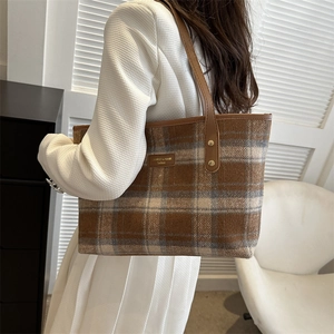 Chic brown plaid wool tote bag with leather handles shown in a lifestyle setting